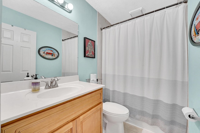 bathroom with toilet, tile patterned flooring, a textured ceiling, and vanity