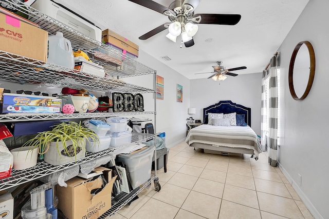 bedroom with light tile patterned floors, visible vents, a ceiling fan, and baseboards