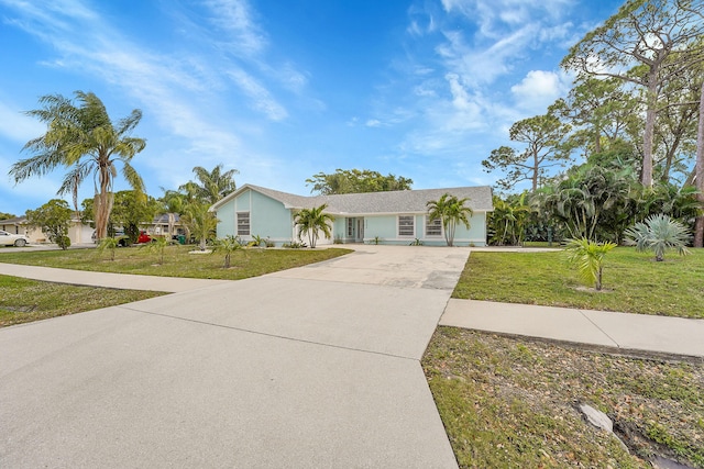 view of front facade featuring concrete driveway and a front yard