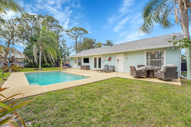 back of property featuring an outdoor pool, a lawn, a patio, french doors, and stucco siding