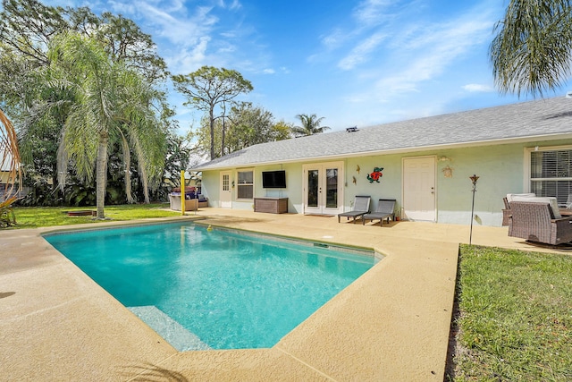 outdoor pool with a patio area, a yard, and french doors