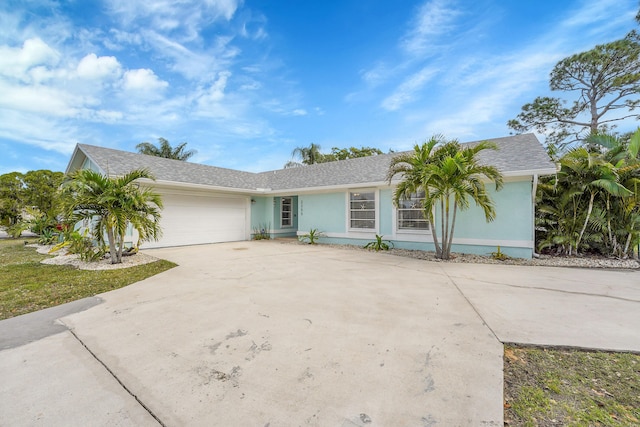 ranch-style home featuring an attached garage, concrete driveway, and stucco siding