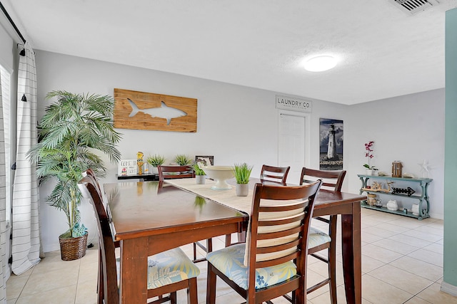 dining room with visible vents, a textured ceiling, and light tile patterned floors