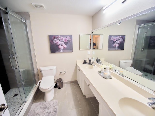 full bathroom featuring toilet, double vanity, visible vents, and a sink