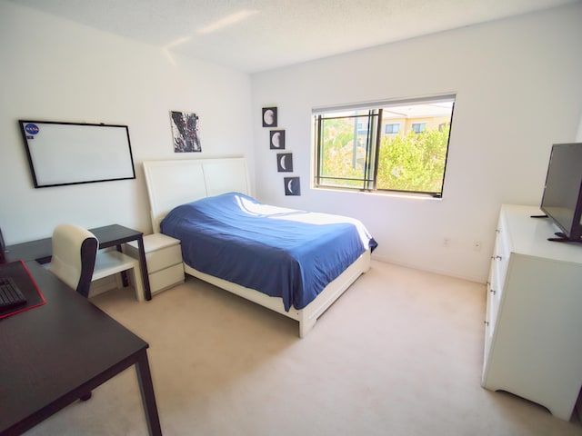 bedroom with light carpet and a textured ceiling