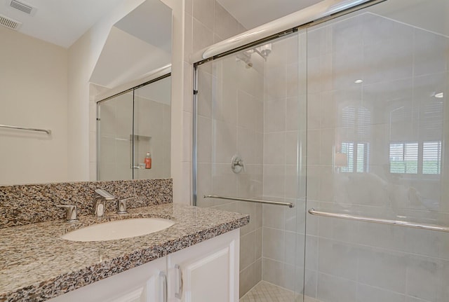 full bathroom with a stall shower, visible vents, and vanity