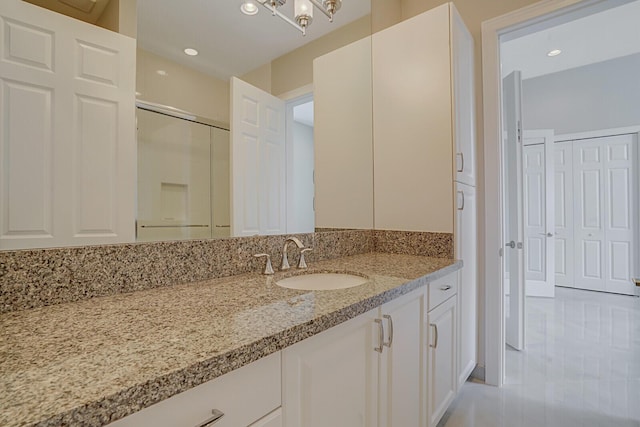 bathroom with recessed lighting, a shower with shower door, and vanity