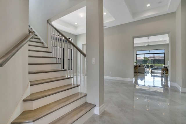 stairway featuring recessed lighting, a raised ceiling, and baseboards