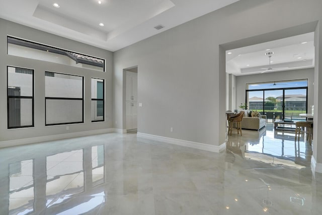 unfurnished room with visible vents, baseboards, a raised ceiling, a ceiling fan, and recessed lighting