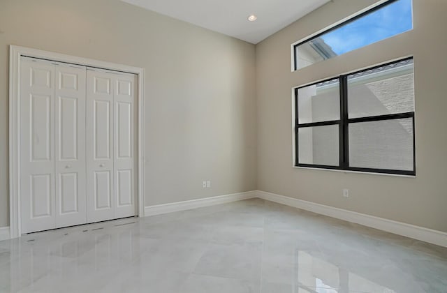 unfurnished bedroom with a closet and baseboards