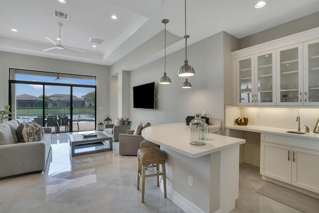 kitchen with open floor plan, visible vents, and white cabinetry