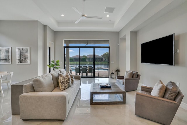 living room featuring ceiling fan, recessed lighting, a raised ceiling, and baseboards