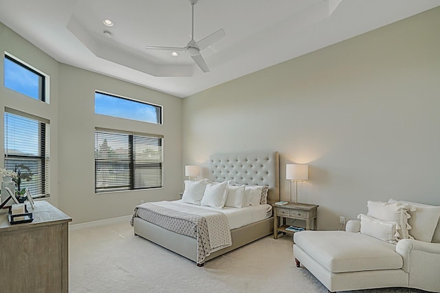 bedroom with light carpet, baseboards, a ceiling fan, a tray ceiling, and recessed lighting