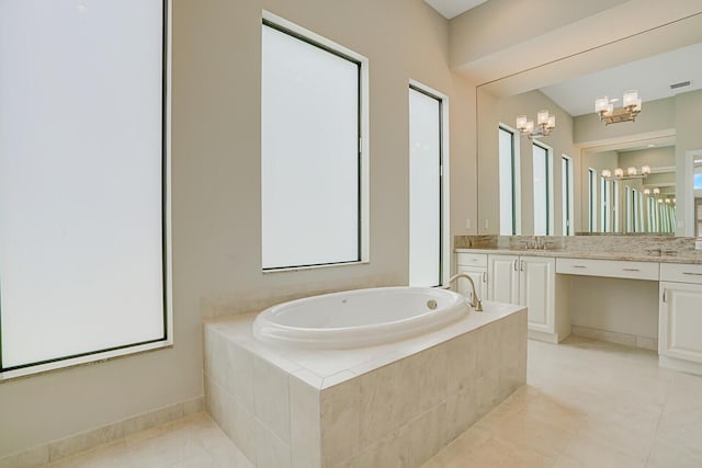 bathroom featuring tile patterned floors, vanity, a bath, and an inviting chandelier