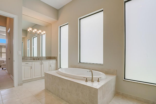 bathroom with tile patterned floors, baseboards, a bath, and vanity