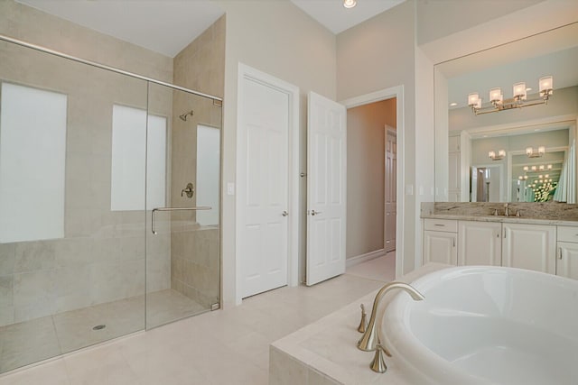 bathroom with a chandelier, a stall shower, a garden tub, and vanity