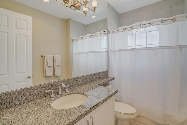 full bathroom featuring curtained shower, vanity, and toilet