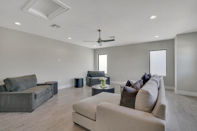 living room with recessed lighting, visible vents, baseboards, light wood-type flooring, and attic access