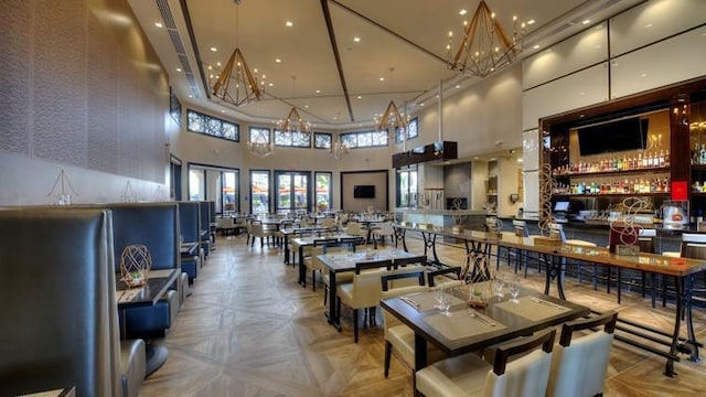 dining area with an inviting chandelier and a high ceiling