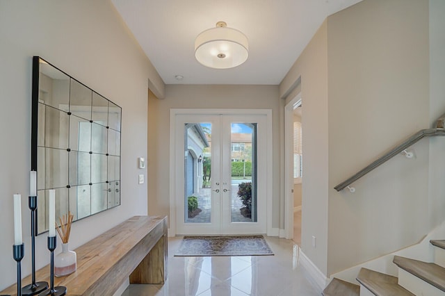 tiled foyer with stairs, baseboards, and french doors