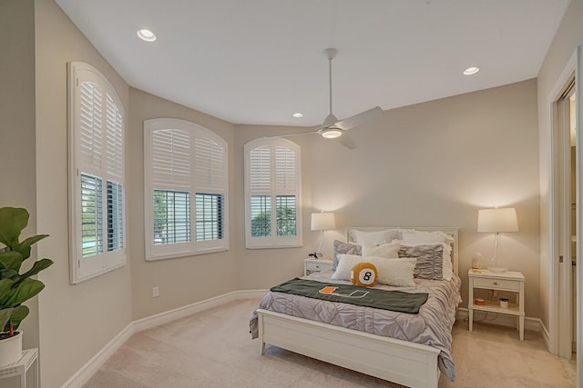 bedroom featuring a ceiling fan, recessed lighting, light colored carpet, and baseboards