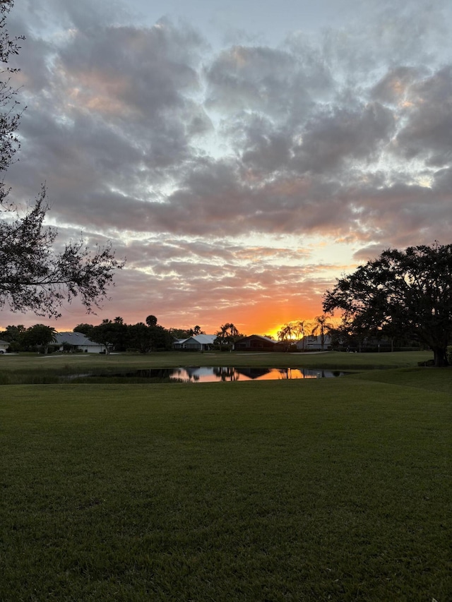 view of property's community featuring a yard and a water view