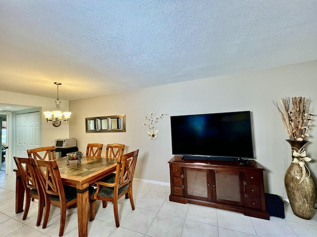 dining space featuring an inviting chandelier, light tile patterned floors, baseboards, and a textured ceiling