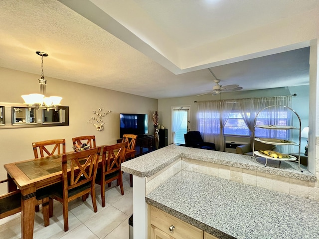 dining space featuring light tile patterned floors, ceiling fan with notable chandelier, and a textured ceiling