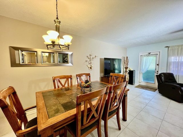 dining area featuring a textured ceiling, a chandelier, and light tile patterned flooring