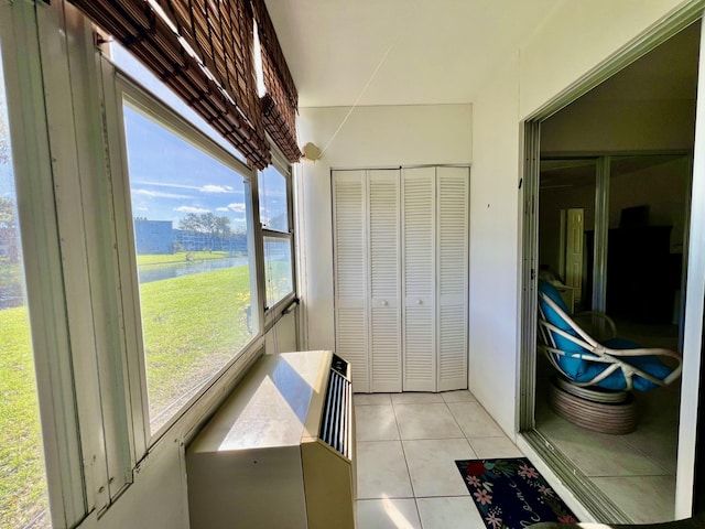 sunroom featuring a water view