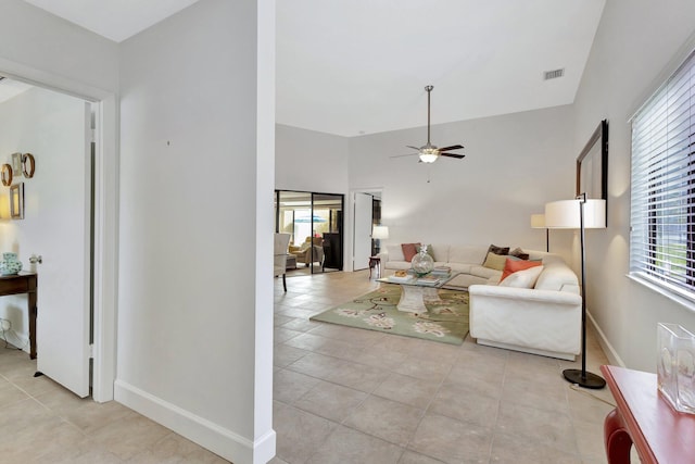 living room with ceiling fan, plenty of natural light, visible vents, and baseboards