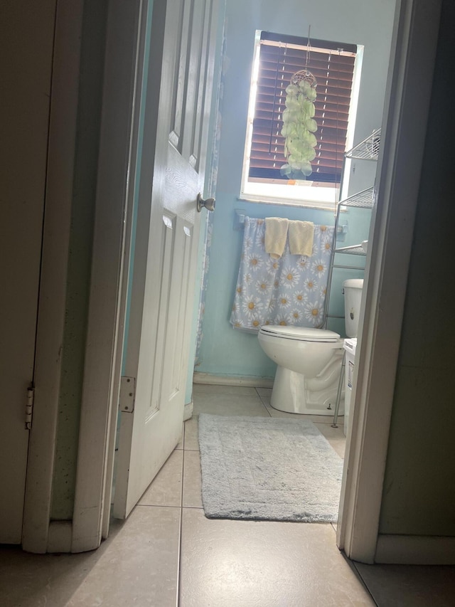 half bath with tile patterned floors and toilet