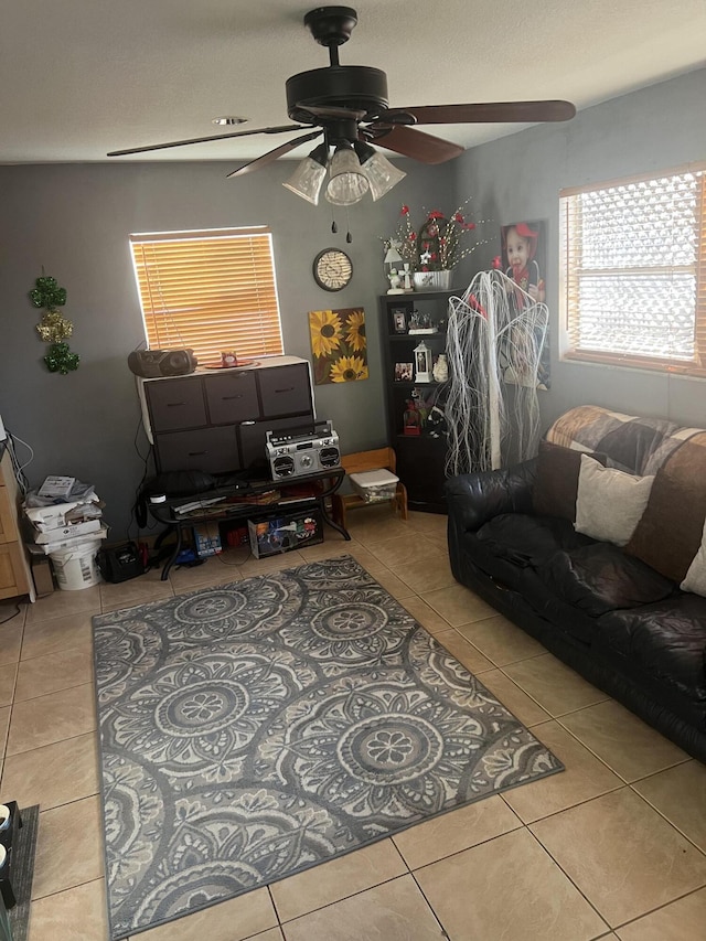 living area with ceiling fan and light tile patterned floors