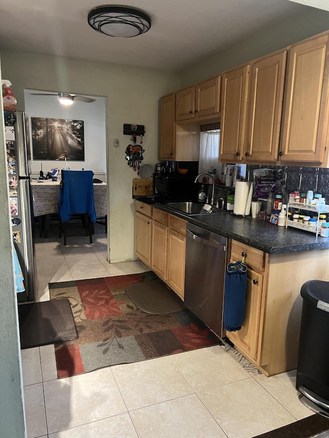 kitchen featuring a sink, appliances with stainless steel finishes, dark countertops, light brown cabinetry, and light tile patterned flooring