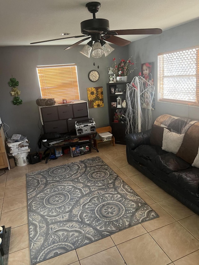 living room with a ceiling fan and tile patterned flooring