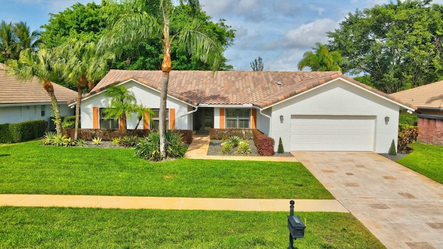 view of front of home with driveway, a tile roof, a garage, and a front lawn