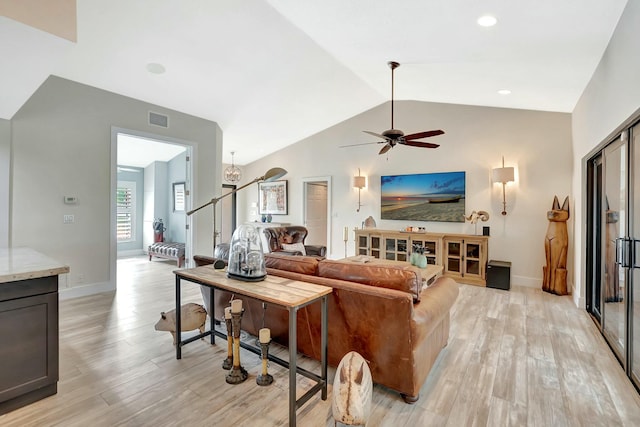 living area featuring light wood-style floors, lofted ceiling, visible vents, and stairs