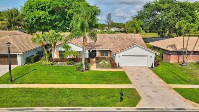 view of front facade with a garage, a tiled roof, concrete driveway, and a front yard