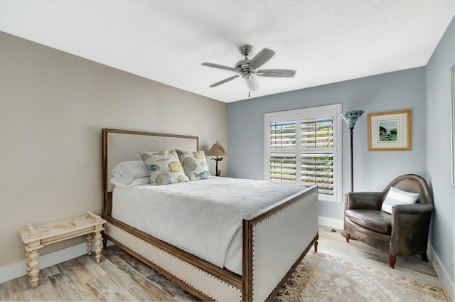 bedroom featuring light wood-type flooring, ceiling fan, and baseboards