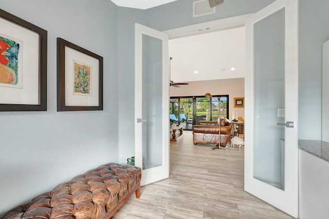 corridor featuring french doors, light wood-type flooring, and visible vents