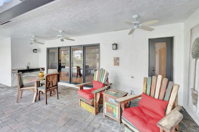 view of patio / terrace with a ceiling fan and a sink