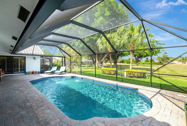 pool featuring glass enclosure, a patio area, and a yard