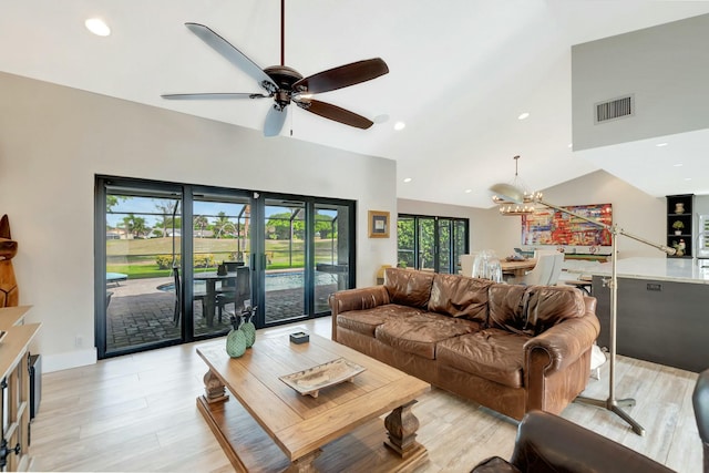 living room featuring recessed lighting, ceiling fan with notable chandelier, visible vents, vaulted ceiling, and light wood finished floors