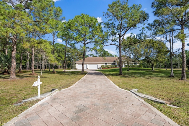 view of front of home featuring driveway, a garage, and a front yard