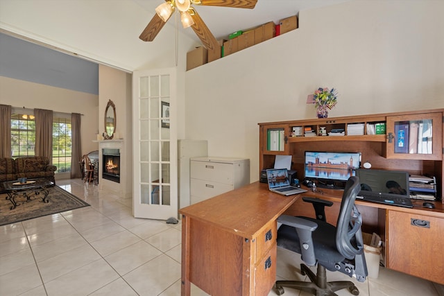 2891 SE Tailwinds Rd, Jupiter, FL 33478 - office with a ceiling fan, light tile patterned flooring, a lit fireplace, and a towering ceiling