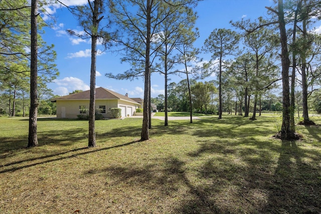 2891 SE Tailwinds Rd, Jupiter, FL 33478 - view of grassy yard with an attached garage