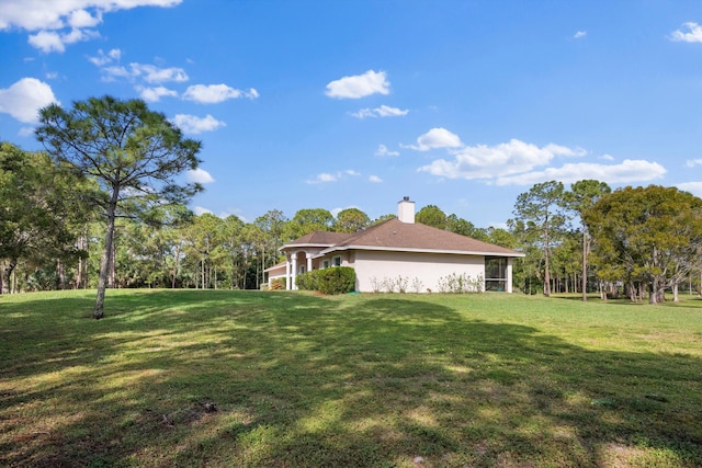 2891 SE Tailwinds Rd, Jupiter, FL 33478 - view of home's exterior with a lawn, a chimney, and stucco siding