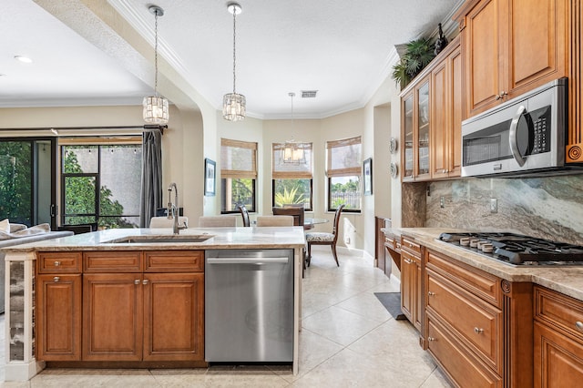 kitchen featuring crown molding, appliances with stainless steel finishes, brown cabinetry, and a sink