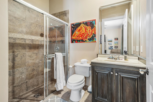 full bathroom featuring vanity, a shower stall, toilet, and crown molding