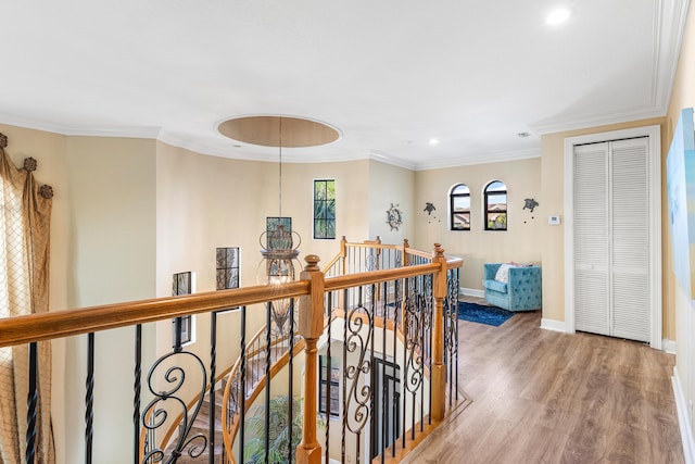 corridor with baseboards, crown molding, an upstairs landing, and wood finished floors